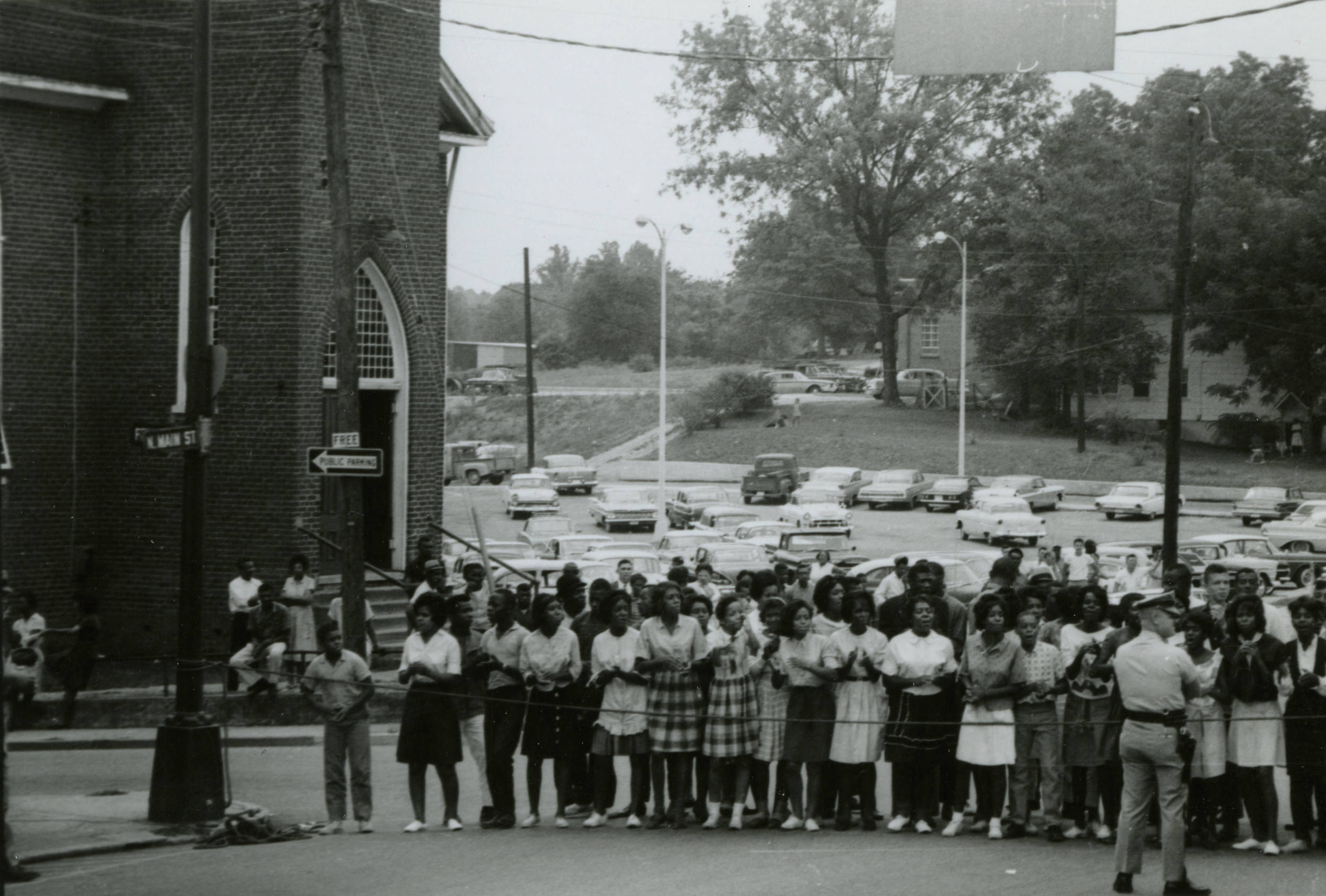 An image of African American students outside of First Baptist Church, with law enforcement officers present